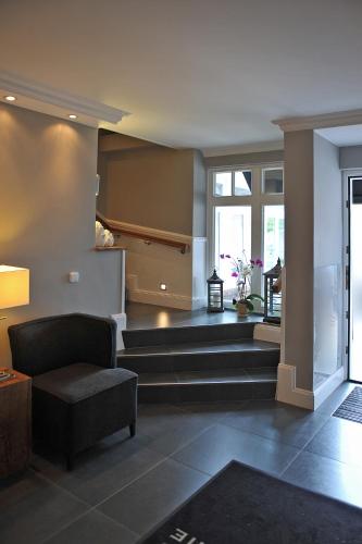 a living room with a couch and a chair at Hotel und Landhaus 'Kastanie' in Hamburg