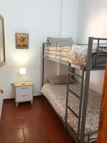 een kamer met 2 stapelbedden en een tafel bij Apartamento La Real 2 in San Nicolás