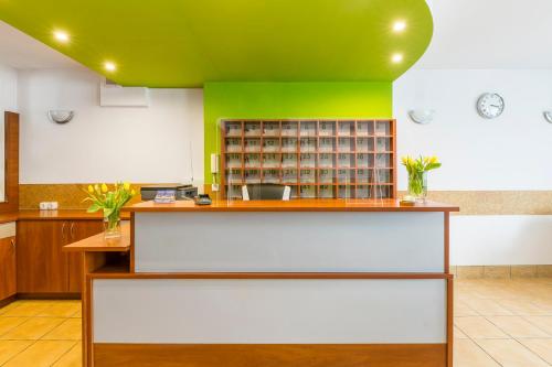 a room with a green wall and a counter at EndHotel Bielany Wroclawskie in Bielany Wrocławskie