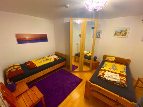 ein kleines Zimmer mit 2 Betten und einem Spiegel in der Unterkunft Ferienwohnung Aretsried in Fischach