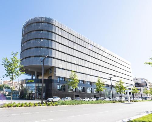 un edificio con macchine parcheggiate di fronte di B&B HOTEL Nice Aéroport Arenas a Nizza