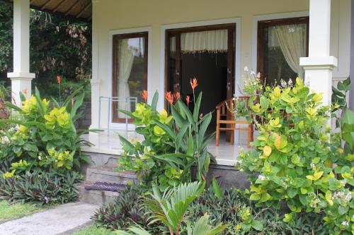 a front porch of a house with flowers and plants at Pondok Aldi in Amed