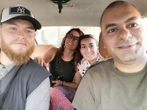 a group of people sitting in the back of a van at david hostel in Aswan