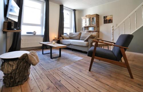 a living room with a couch and a tv at La Roche ô Tour! - Gîte citadin in La Roche-en-Ardenne