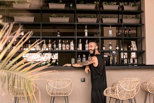 a man standing behind a counter in a bar at Sunny Beach Club - Adults Only #YouthfulVibes in Sunny Beach