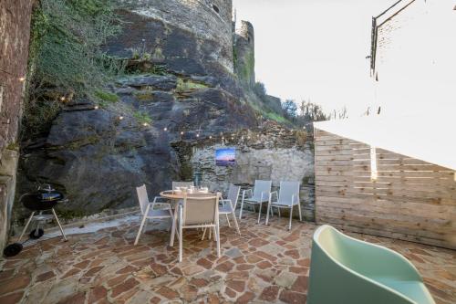 a patio with a table and chairs and a wall at La Roche ô Tour! - Gîte citadin in La Roche-en-Ardenne