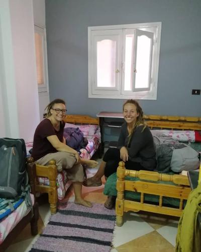 two women sitting on beds in a room at david hostel in Aswan