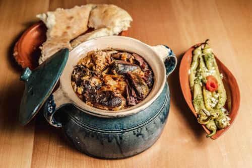 a pot of food sitting on a table with a plate of food at KONAK LJUBICA Rtanj in Boljevac