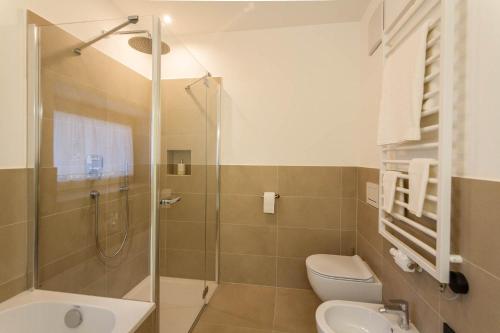 a bathroom with a shower and a toilet and a sink at Residence Villa Schlern in Fiè