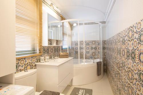 a bathroom with a tub and a sink and a toilet at SKAI Two Floor Apartment in Vasiliki