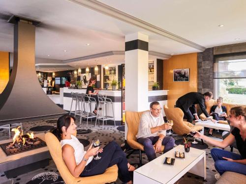 a group of people sitting in chairs in a room at Mercure Cabourg Hôtel & Spa in Cabourg
