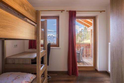 Schlafzimmer mit Etagenbetten und Balkon mit Fenster in der Unterkunft Golserhof Sonne in Steinhaus