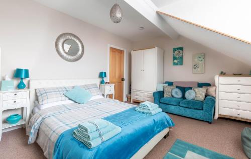 ファイリーにあるNumber 12 Yorkshire Holiday Houseのベッドと青いソファのある寝室