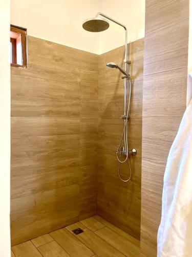a bathroom with a shower with a wooden wall at Amani Boutique Hotel - Small Luxury Hotels of the World in Paje