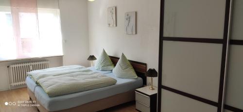 - une chambre avec un lit doté de draps et d'oreillers blancs dans l'établissement Strandfee, à Grömitz