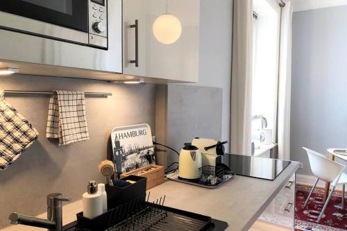 a kitchen with a counter with a coffee maker on it at Stadtpark-Domizil - 70 qm, zentral & ruhig in Hamburg