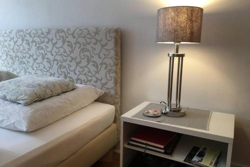 a lamp on a night stand next to a bed at Stadtpark-Domizil - 70 qm, zentral & ruhig in Hamburg