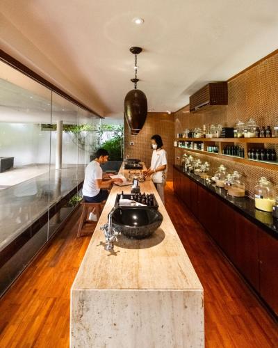two people standing in a kitchen with a counter at Alila Diwa Goa - A Hyatt Brand in Majorda
