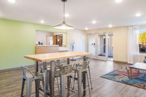 a kitchen and dining room with a wooden table and chairs at WoodSpring Suites Jacksonville Baymeadows in Jacksonville