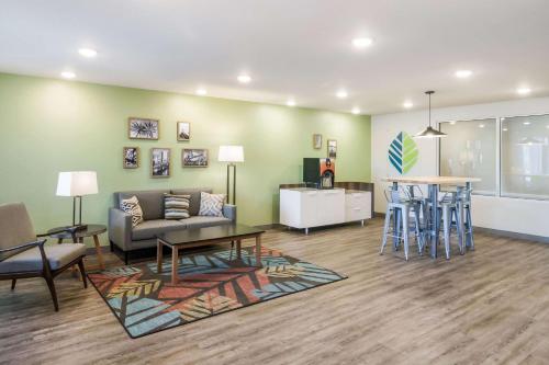 a living room with a couch and a table at WoodSpring Suites Jacksonville Baymeadows in Jacksonville