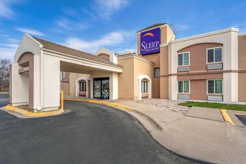 a hotel with a sign on the side of a building at Sleep Inn & Suites Omaha Airport in Omaha