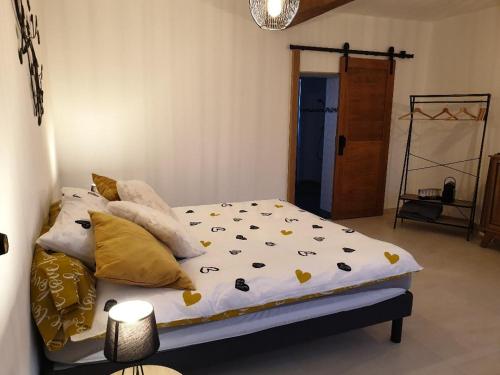 a bedroom with a bed with yellow and white sheets at La Clef des Champs in Potelle