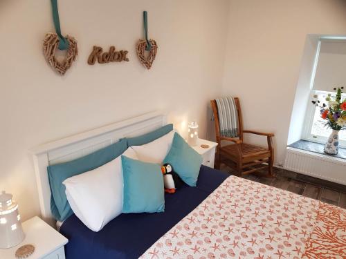 a bedroom with a bed with blue and white pillows at The Coral Cottage in Doolin