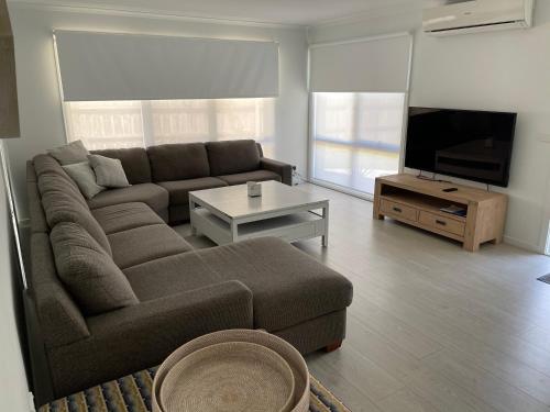 a living room with a couch and a flat screen tv at Beach House Getaway 2 in Smiths Beach