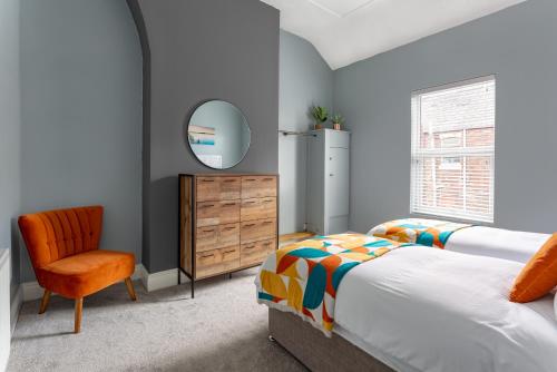 リバプールにあるWatford House - Air Host & Stay - 3 Bedroom Period Houseのベッドと椅子と鏡のある寝室