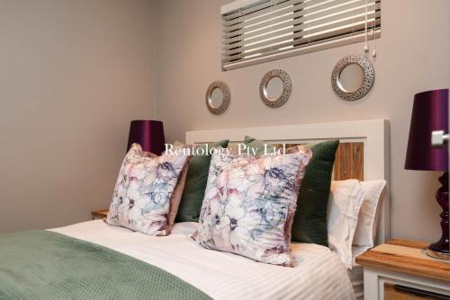 a bedroom with a bed and two mirrors on the wall at Lovely 1 Bed Zimbali Suites in Ballito