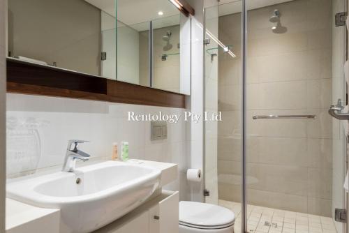 a bathroom with a sink and a toilet and a shower at Lovely 1 Bed Zimbali Suites in Ballito