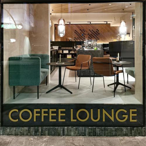 a coffee lounge with tables and chairs in a store window at Glanz & Glory Appartements Sölden in Sölden