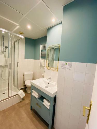 ディナールにあるHotel du Parcの洗面台、シャワー、トイレ付きのバスルーム