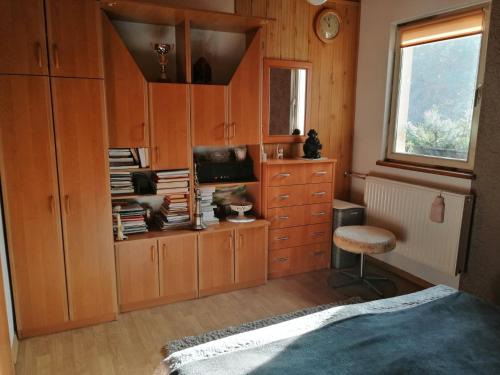 - une chambre avec des placards en bois, un bureau et une chaise dans l'établissement Agroturystyka Maria i Jan Bryjka, à Mikorowo