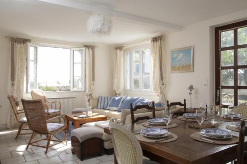 un salon avec une table et des chaises dans l'établissement FLEUR DE SEL, à Saint-Trojan-les-Bains