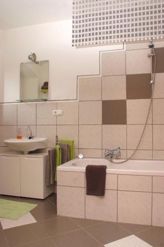 a bathroom with a sink and a tub and a mirror at Ferienwohnung "Völkl" in Tännesberg