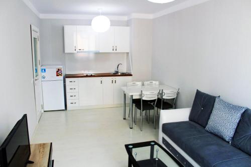 a living room and kitchen with a couch and a table at APART-HOTEL Stamopolu Lux с изглед към морето in Primorsko
