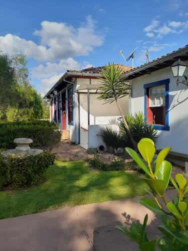a small white house with a window and a yard at Pousada Araujo Bazilio in Tiradentes