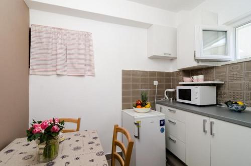 a small kitchen with a table and a microwave at Guest House Ćuk in Dubrovnik