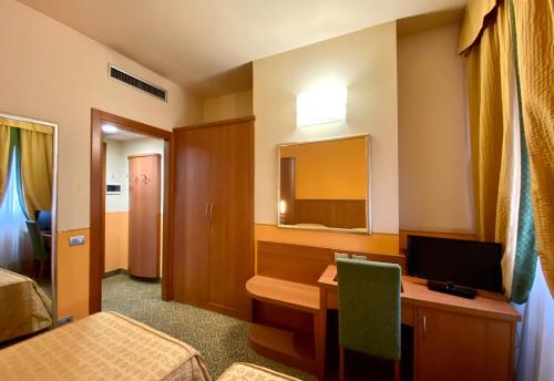 a room with a desk with a computer and a bed at Hotel Kristall in Corsico