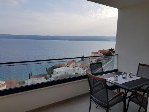 a balcony with a table and chairs and a view of the water at La Vista apartments in Mimice