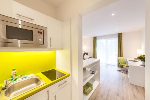 una cucina con lavandino e forno a microonde di acora Fürth Living the City- Apartments a Fürth