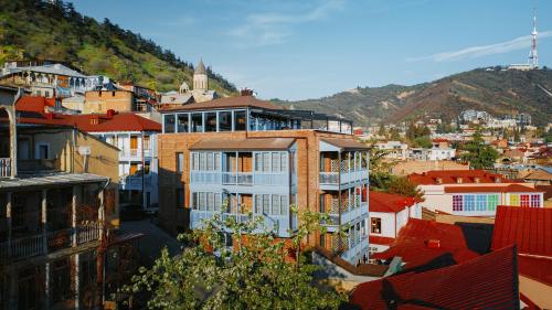 a view of a city with buildings and a mountain at TbiliSee Hotel in Tbilisi City