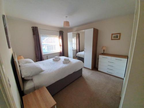 a bedroom with a bed and a dresser and a mirror at Beverley Central Townhouse Free Parking Sleeps 8 in Beverley