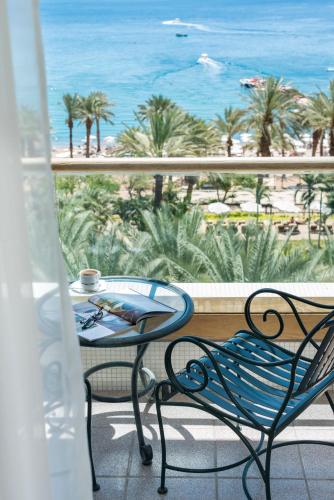 a table and chairs on a balcony with a view of the beach at Royal Beach Eilat by Isrotel Exclusive in Eilat