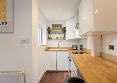 a kitchen with white cabinets and a sink at Stylish Upper Gardner Street - With Free Parking in Brighton & Hove