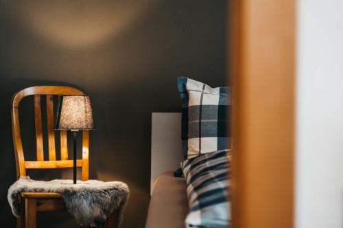 a chair and a lamp next to a bed at Charming 4 bed flat in Flims in Flims
