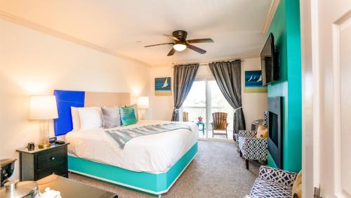 a bedroom with a bed and a ceiling fan at Regatta Inn - Adults Only in Folly Beach