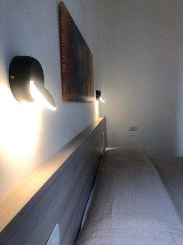 Bett in einem Zimmer mit zwei Lichtern an der Wand in der Unterkunft Hotel Nazionale in Florenz