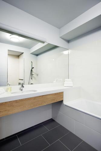 a bathroom with two sinks and a large mirror at Boulevard Ustronie Morskie by Zdrojowa in Ustronie Morskie